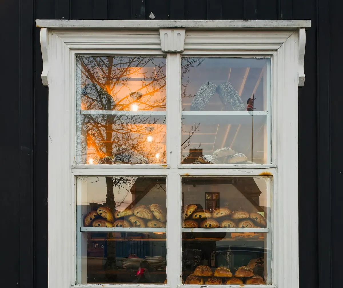 Vitrine éclairée de la boulangerie, avec croissants et pains au chocolat sur les étagères